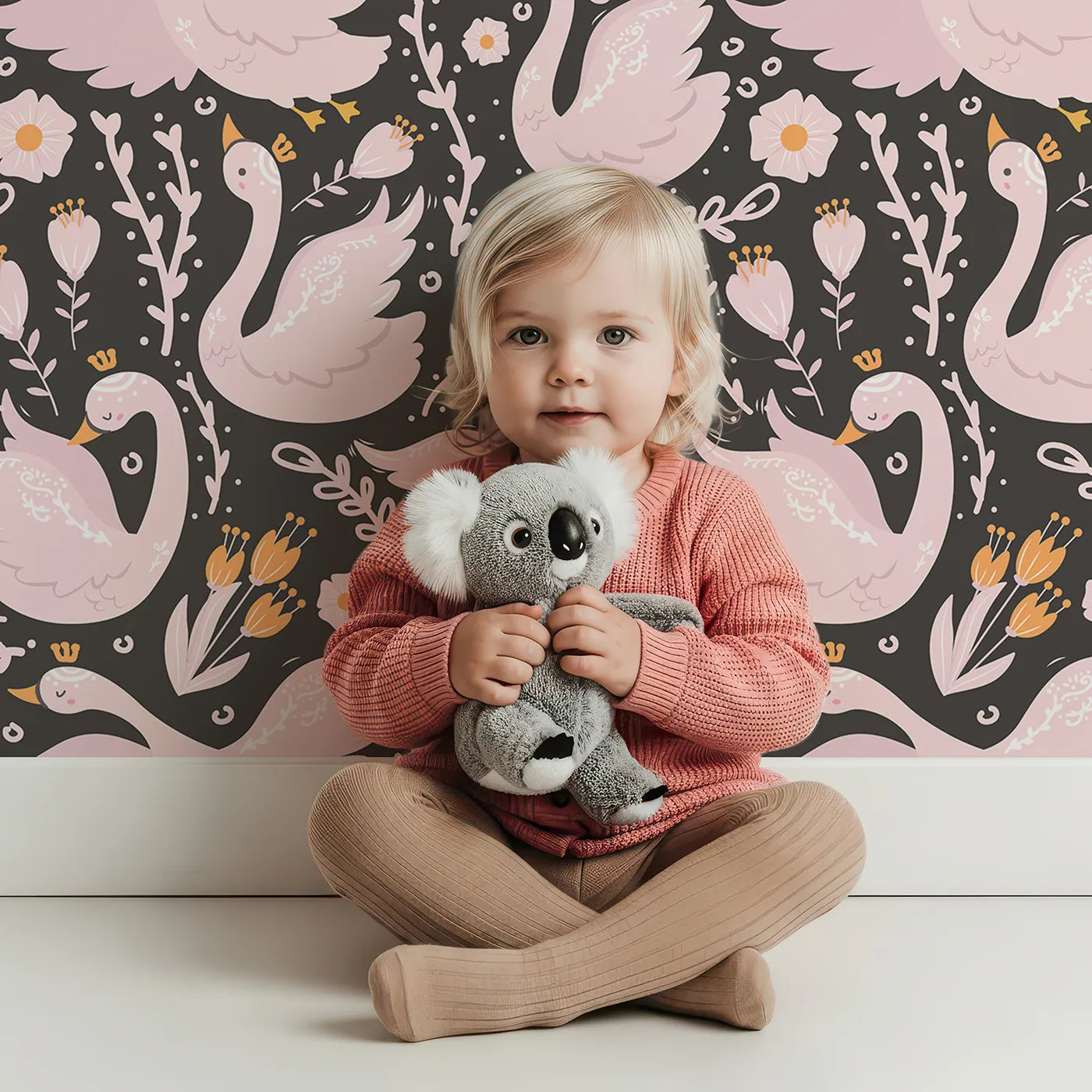 Lovely child standing in front of Whimsy Tots Starlit Swan Ballet Wallpaper in Charcoal Black with swan, crown, flower, bow, leaf in design.