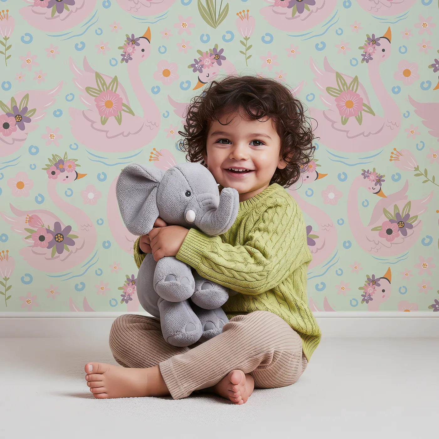 Lovely child standing in front of Whimsy Tots Blooming Swan Garden Wallpaper in Mint Green with swan, flower, crown, tulip, ripple in design.