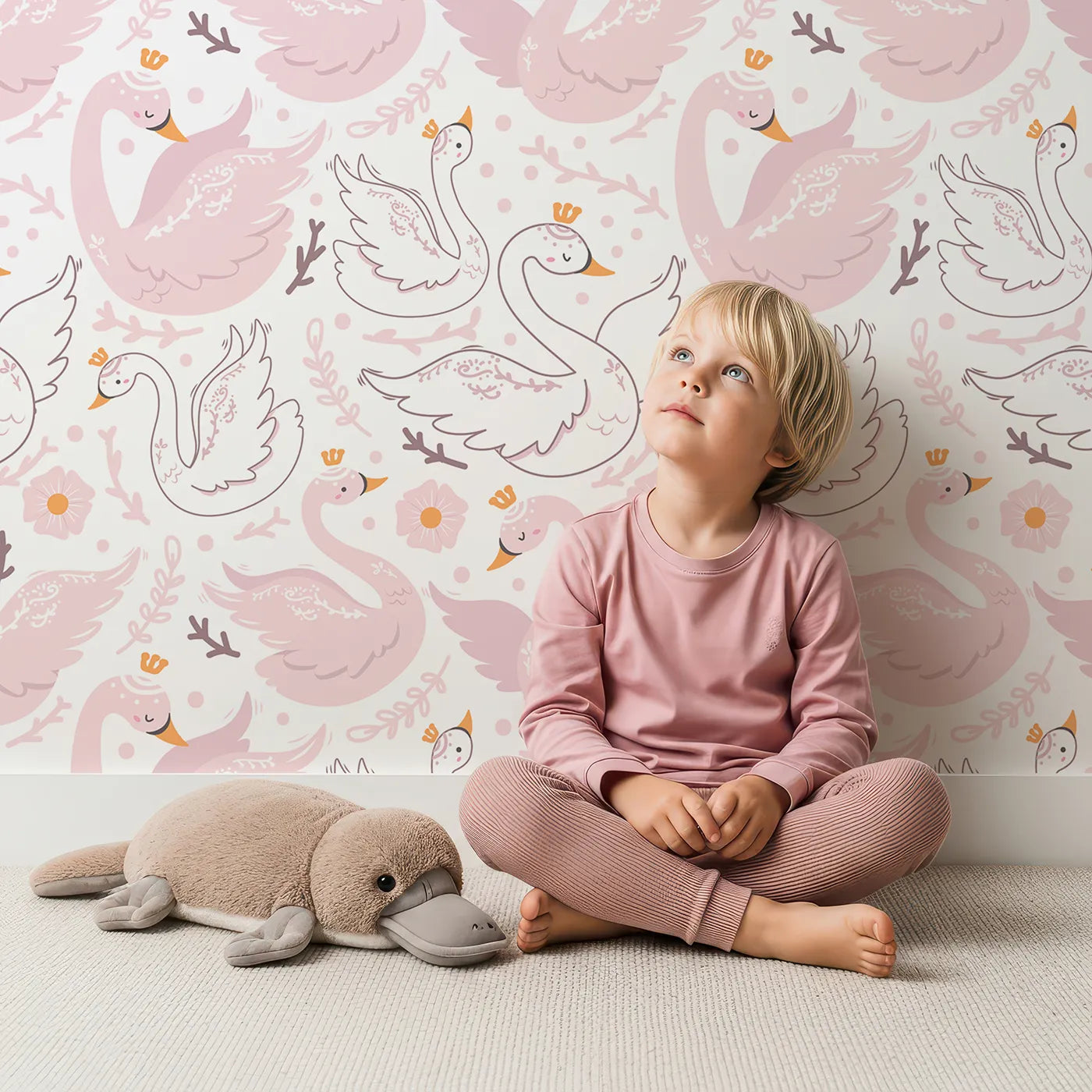 Lovely child standing in front of Whimsy Tots Crowning Swan Ballet Wallpaper in Blush with swan, flower, crown, heart in design.