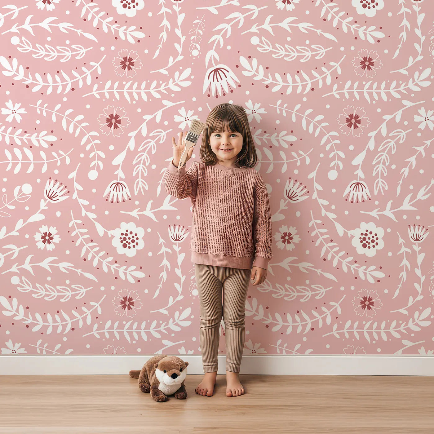 Lovely child standing in front of Whimsy Tots Spring Meadow Whispers Wallpaper in Blush Pink with flower, vine, leaf, dot in design.