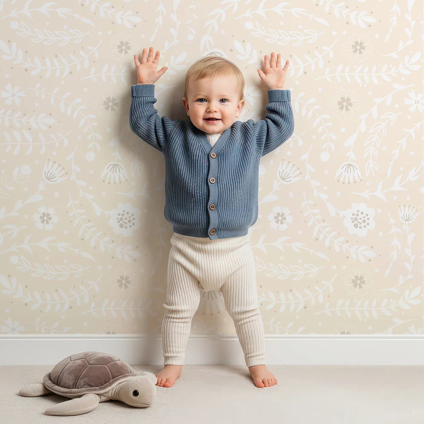 Lovely child standing in front of Whimsy Tots Spring Meadow Whispers Wallpaper in Peach Cream with flower, vine, leaf, dot in design.
