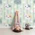 Lovely child standing in front of Whimsy Tots Pawprint Kitty Parade Wallpaper in Mint Green with cat, pawprint, stripe in design. Lovely child standing in front of Whimsy Tots Pawprint Kitty Parade Wallpaper in Mint Green with cat, pawprint, stripe in design.