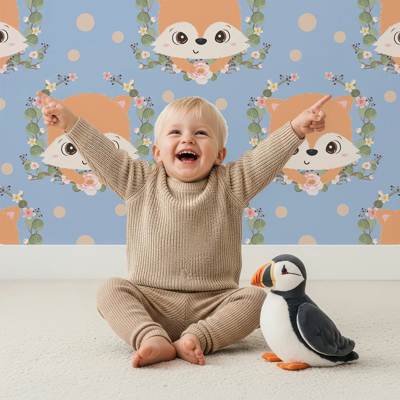 Lovely child standing in front of Whimsy Tots Floral Fox Peek Wallpaper in Dusty Blue with fox, flower, crown, leaf, polka in design.