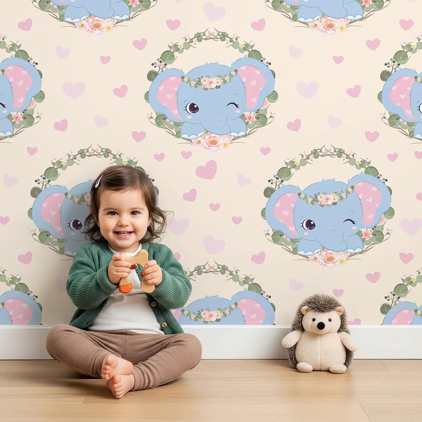 Lovely child standing in front of Whimsy Tots Floral Elephant Wink Wallpaper in Vanilla Cream with elephant, heart, flower, crown, branch, leaf in design.