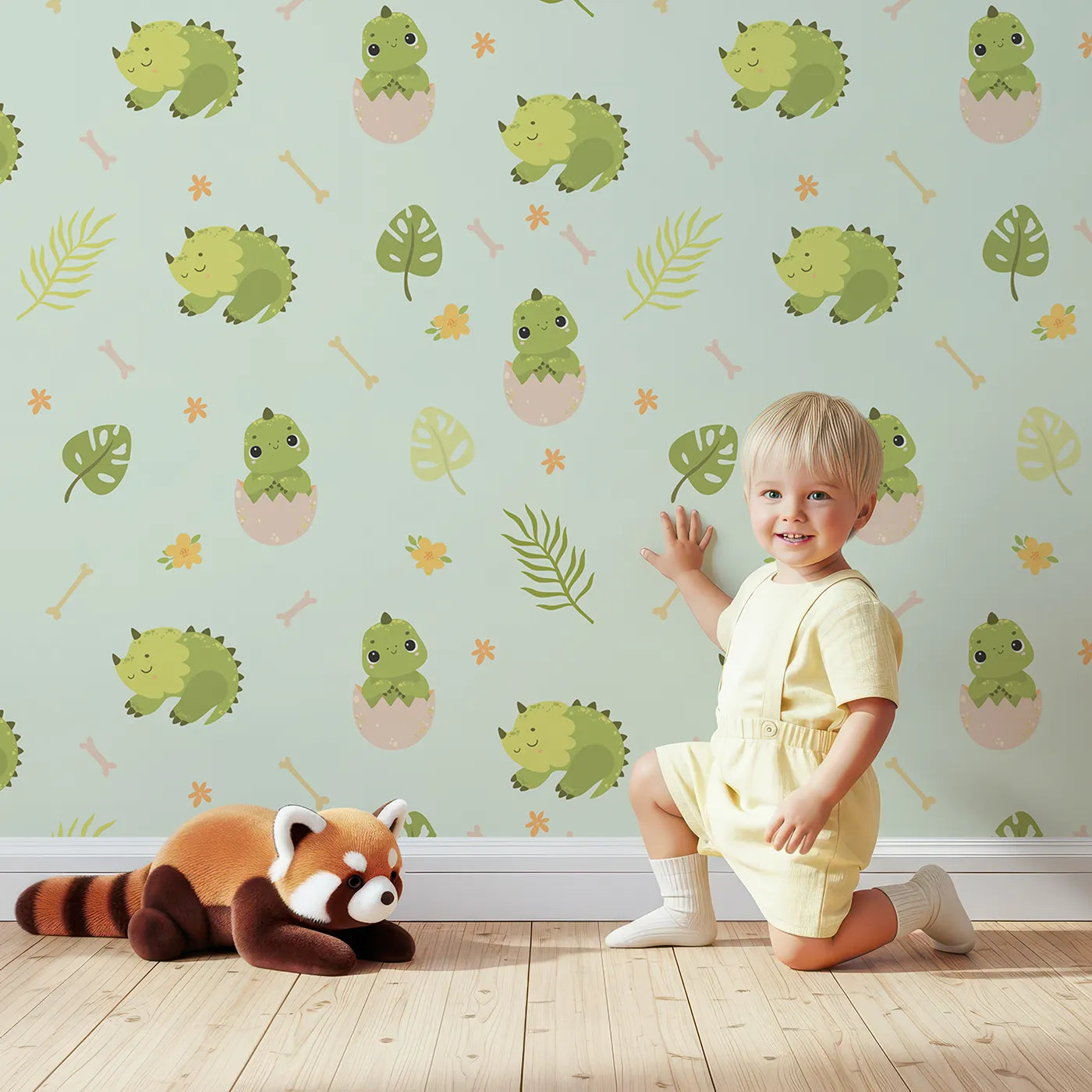 Lovely child standing in front of Whimsy Tots Hatching Dino Friends Wallpaper in Mint Meadow Green with dinosaur, egg, leaf, flower, bone in design.