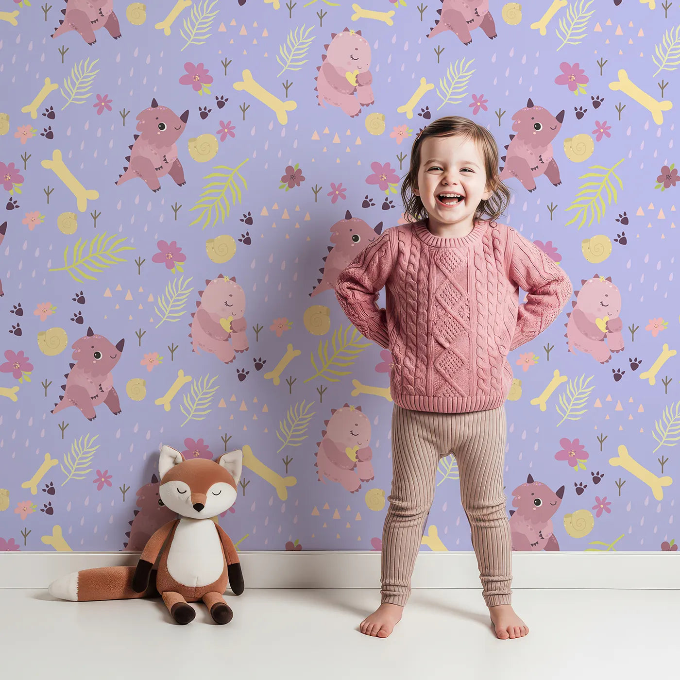 Lovely child standing in front of Whimsy Tots Cuddle Saurus Garden Wallpaper in Lavender Mist with dinosaur, flower, bone, footprint in design.