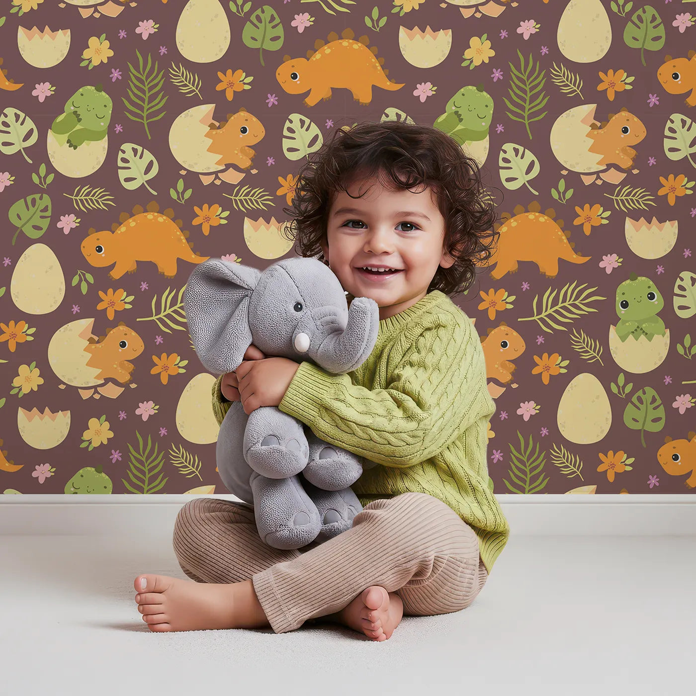 Lovely child standing in front of Whimsy Tots Hatchling Dino Garden Wallpaper in Berry Soil with dinosaur, egg, flower, leaf in design.