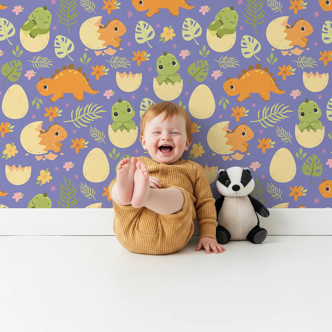 Lovely child standing in front of Whimsy Tots Hatchling Dino Garden Wallpaper in Blossom Lilac Lavender with dinosaur, egg, flower, leaf in design.