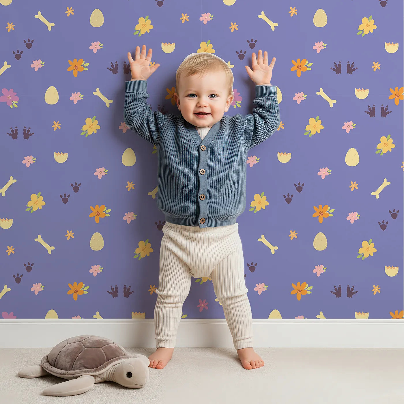 Lovely child standing in front of Whimsy Tots Dino Hatch Trail Wallpaper in Lilac Sky Lavender with egg, bone, flower, footprint in design.