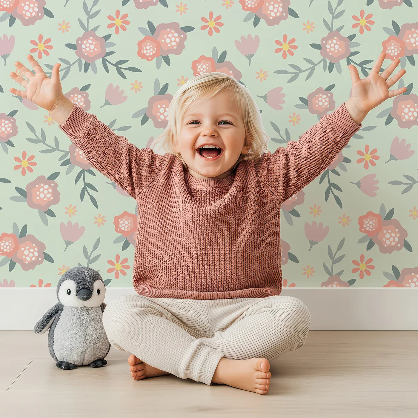 Lovely child standing in front of Whimsy Tots Whispering Peony Garden Wallpaper in Mint Petal Green with flower, peony, daisy, leaf in design.
