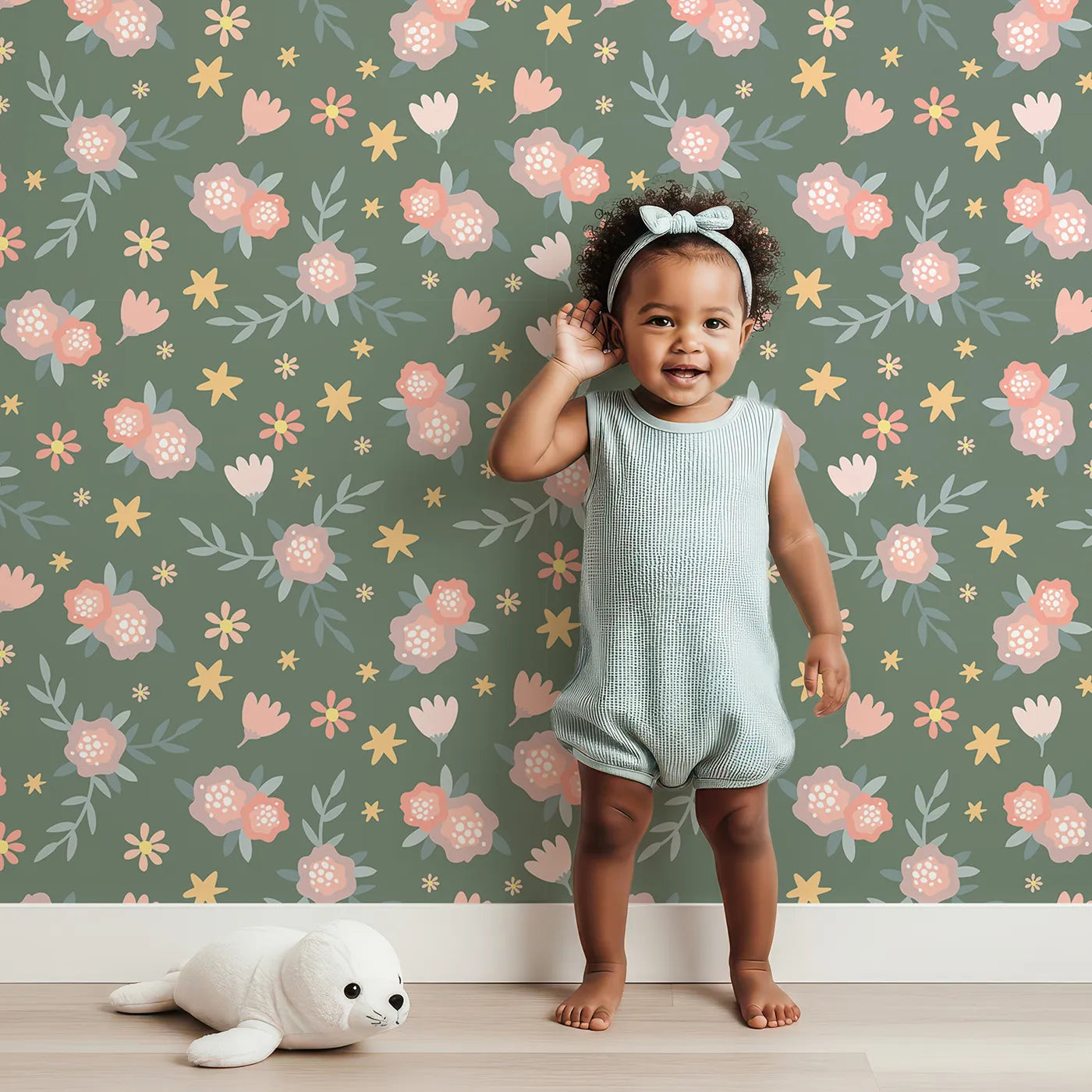 Lovely child standing in front of Whimsy Tots Twilight Garden Whimsy Wallpaper in Moss Bloom with flower, leaf, star, bloom in design.