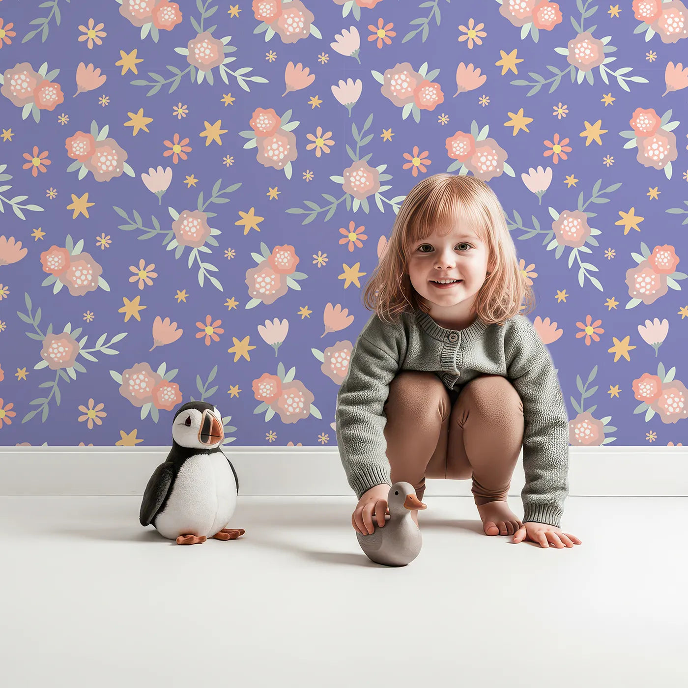 Lovely child standing in front of Whimsy Tots Twilight Garden Whimsy Wallpaper in Periwinkle Dream with flower, leaf, star, bloom in design.
