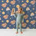Lovely child standing in front of Whimsy Tots Moonlit Bear Dreams Wallpaper in Twilight Sky with bear, flower, moon, star in design. Lovely child standing in front of Whimsy Tots Moonlit Bear Dreams Wallpaper in Twilight Sky with bear, flower, moon, star in design.