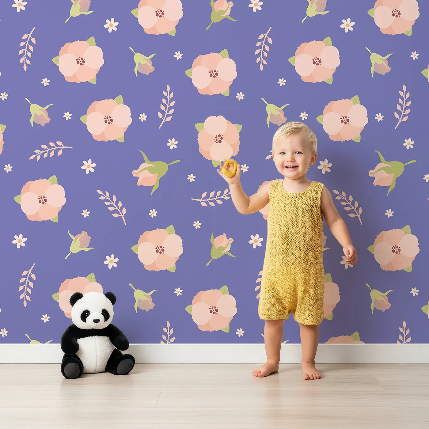 Lovely child standing in front of Whimsy Tots Blush Meadow Bloom Wallpaper in Lavender Bloom with flower, daisy, leaf, petal in design.