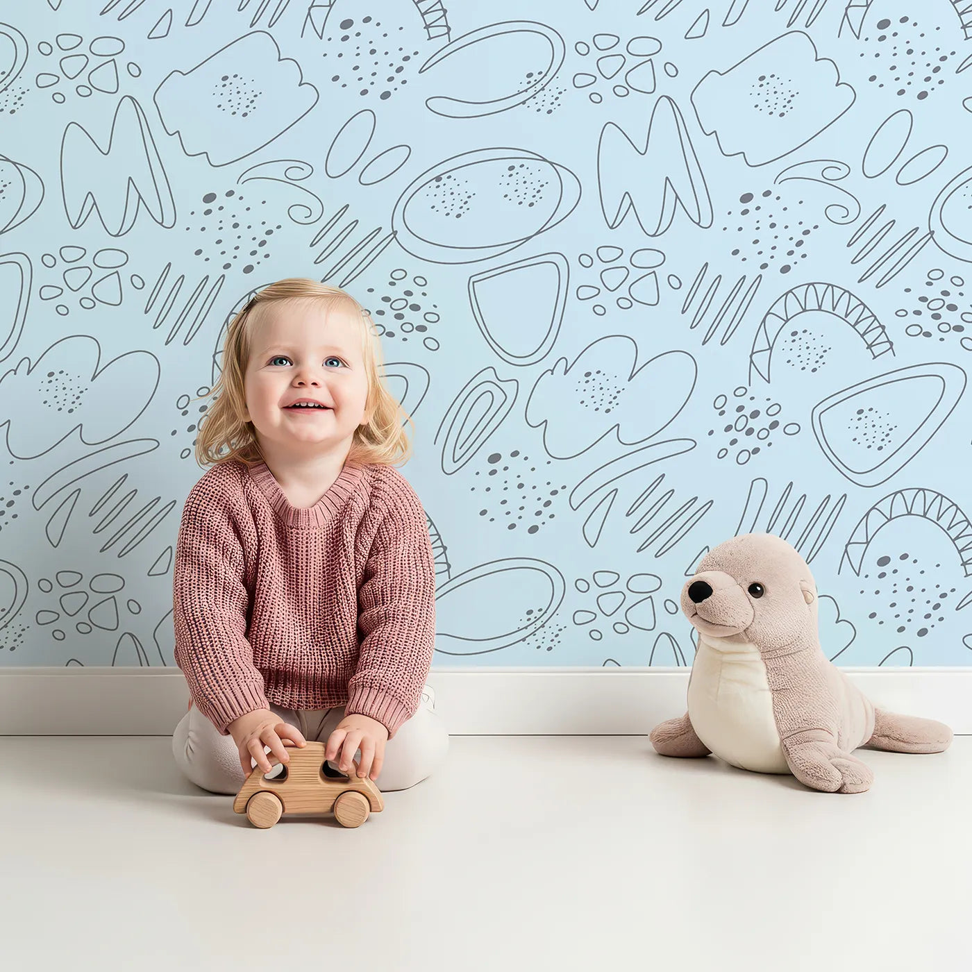 Lovely child standing in front of Whimsy Tots Doodle Meadow Shapes Wallpaper in Sky with doodle, shape, scribble, arch, petal in design.