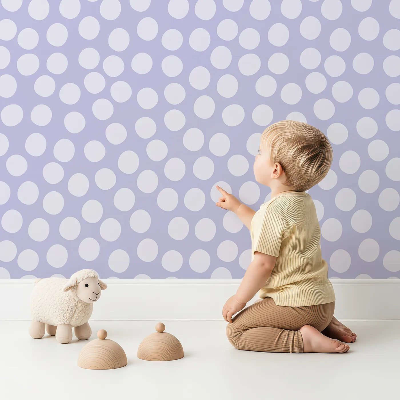 Lovely child standing in front of Whimsy Tots Playful Pebble Dots Wallpaper in Lavender Mist with dot, pebble, spot, oval in design.