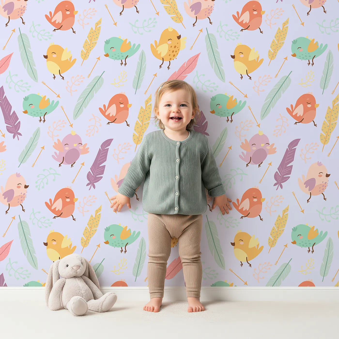 Lovely child standing in front of Whimsy Tots Feathered Joy Parade Wallpaper in Lavender Lilac with bird, feather, sprig, arrow in design.