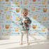 Lovely child standing in front of Whimsy Tots Tribal Bunny Parade Wallpaper in Sky Blue with rabbit, arrow, feather, diamond in design. Lovely child standing in front of Whimsy Tots Tribal Bunny Parade Wallpaper in Sky Blue with rabbit, arrow, feather, diamond in design.