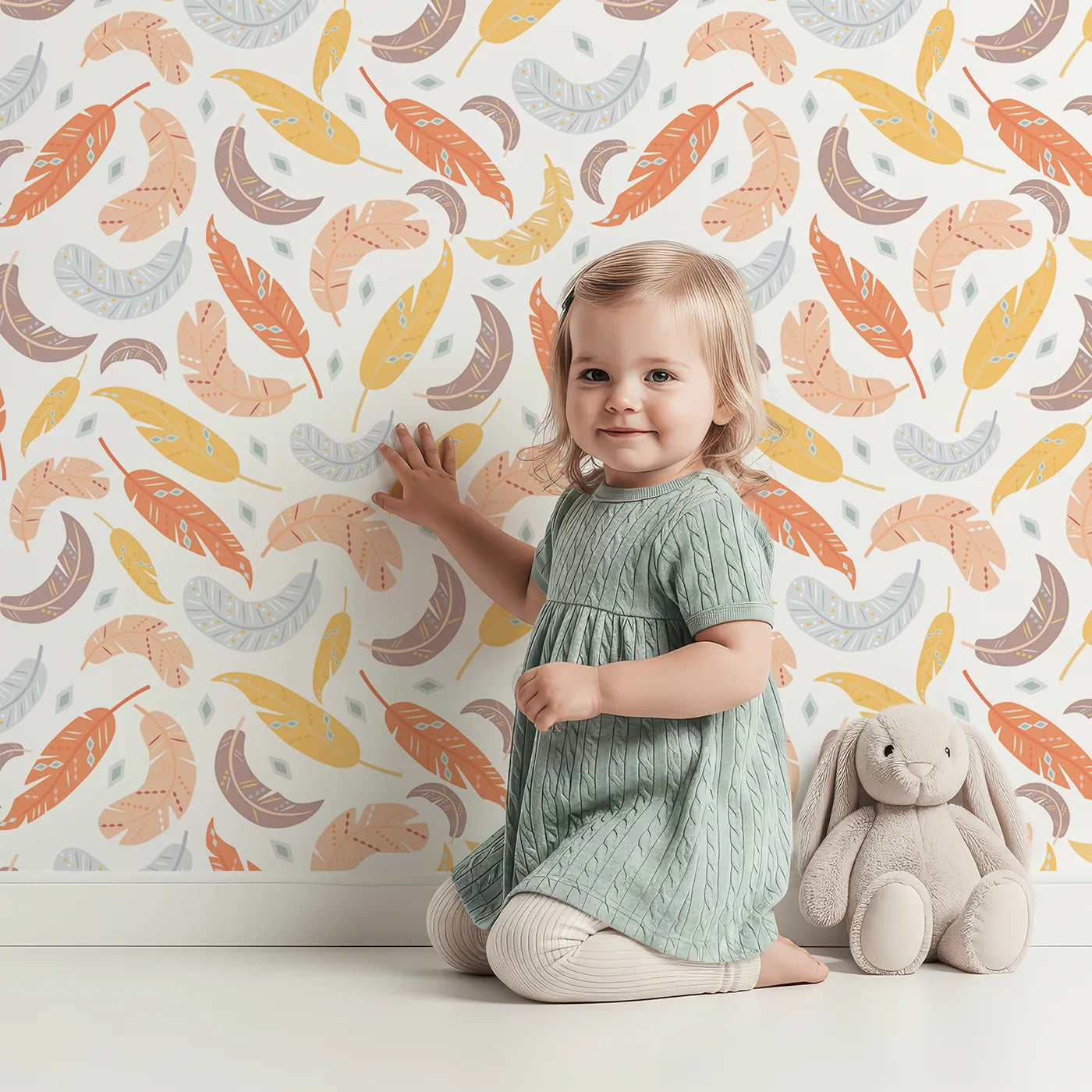 Lovely child standing in front of Whimsy Tots Feathered Whimsy Drift Wallpaper in Vanilla Cream with feather, diamond, dot in design.