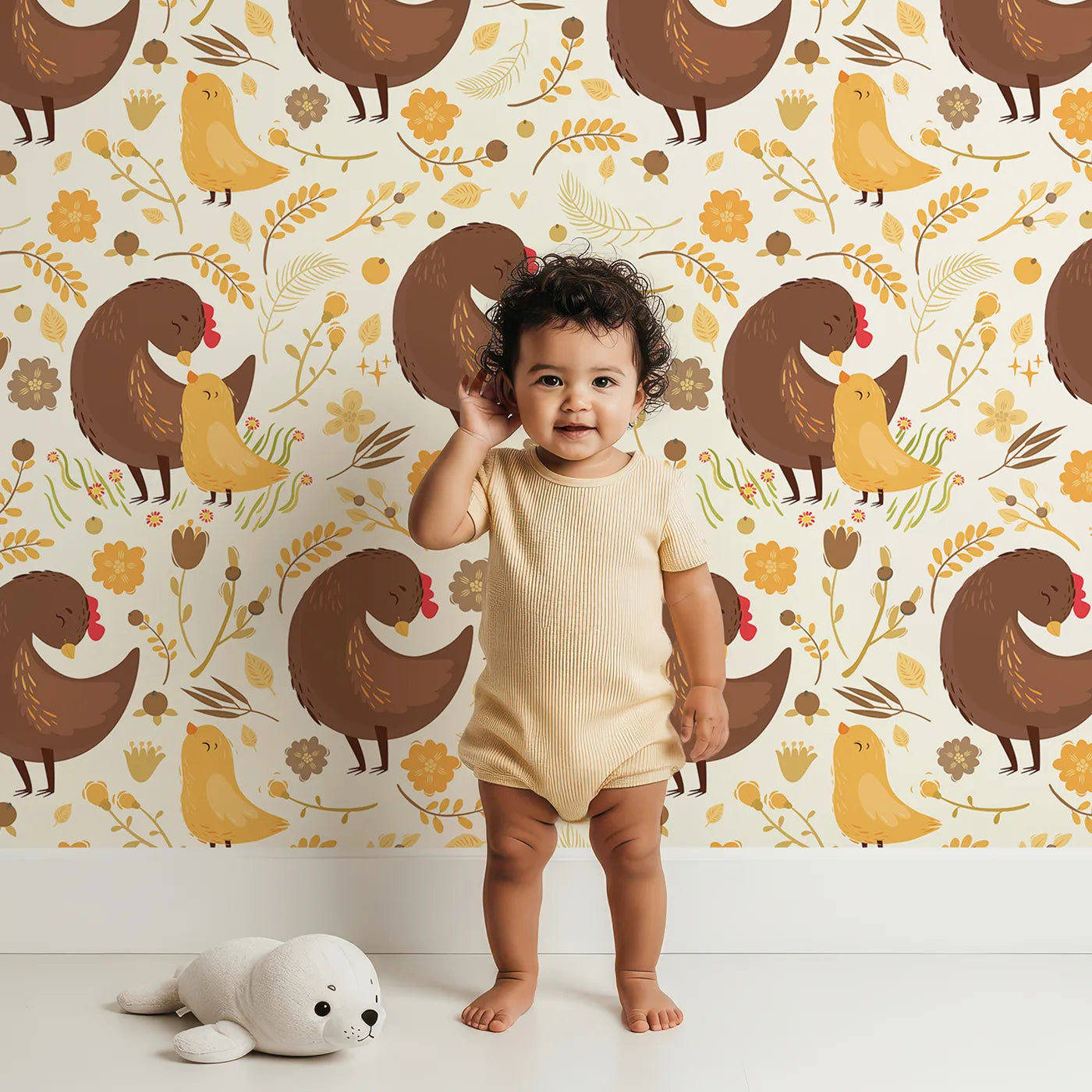 Lovely child standing in front of Whimsy Tots Hen and Chick Meadow Wallpaper in Cream Nest with chicken, chick, flower, leaf in design.