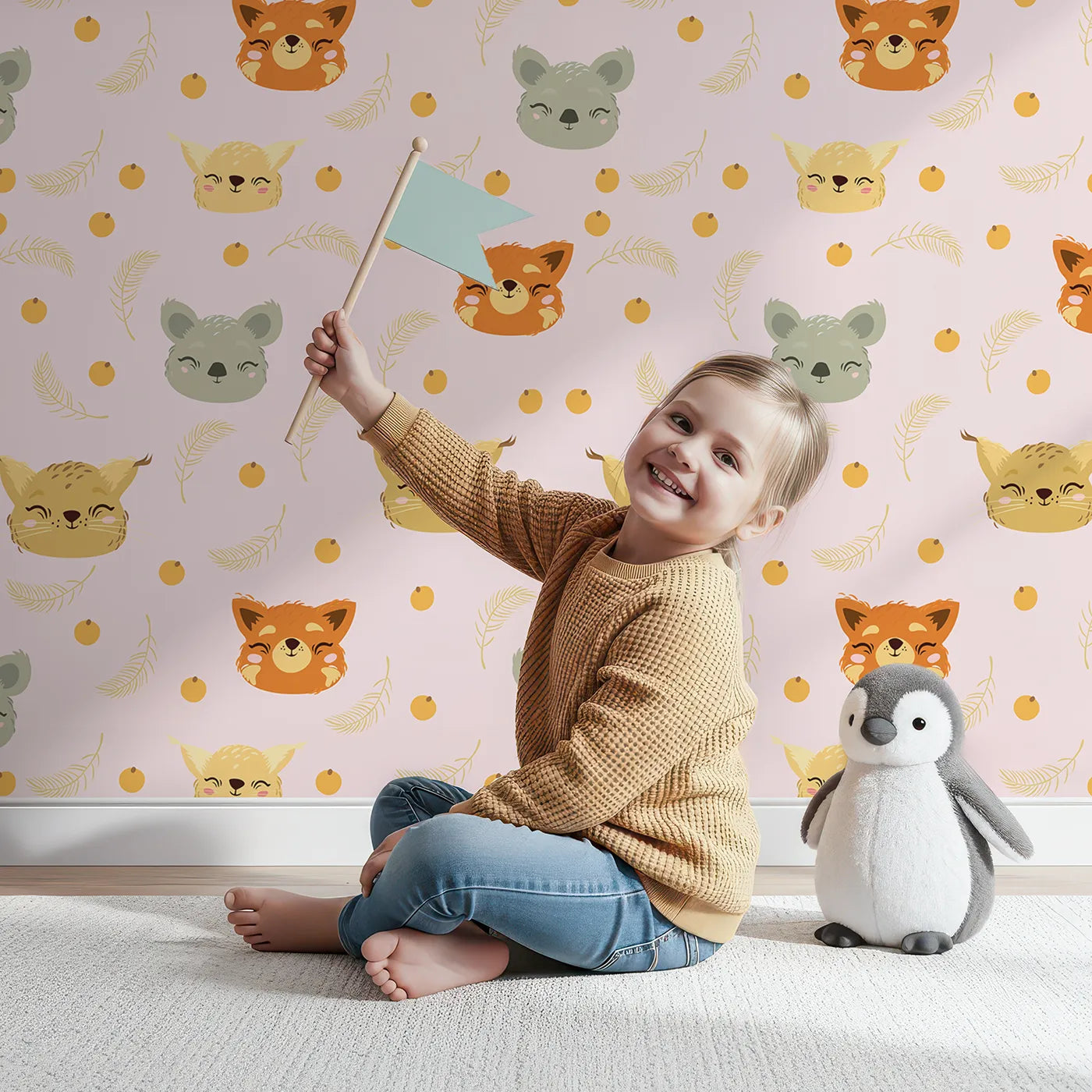 Lovely child standing in front of Whimsy Tots Outback Snuggle Faces Wallpaper in Blush Pink with koala, fox, lynx, feather, berry in design.