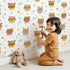 Lovely child standing in front of Whimsy Tots Heart Bloom Critters Wallpaper in White with bear, rabbit, owl, heart, flower, cloud in design. Lovely child standing in front of Whimsy Tots Heart Bloom Critters Wallpaper in White with bear, rabbit, owl, heart, flower, cloud in design.