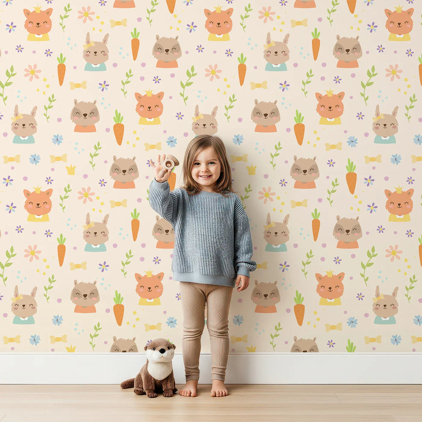 Lovely child standing in front of Whimsy Tots Meadow Crown Friends Wallpaper in Cream with fox, rabbit, bear, flower, carrot, crown, bow in design.