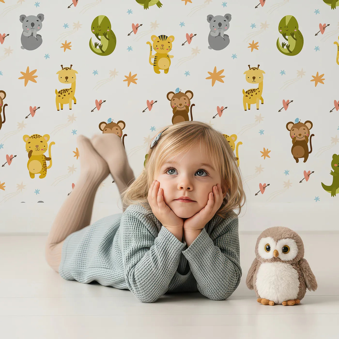 Lovely child standing in front of Whimsy Tots Wild Heart Animal Parade Wallpaper in White with giraffe, koala, leopard, monkey, tiger, crocodile, heart, arrow, star in design.