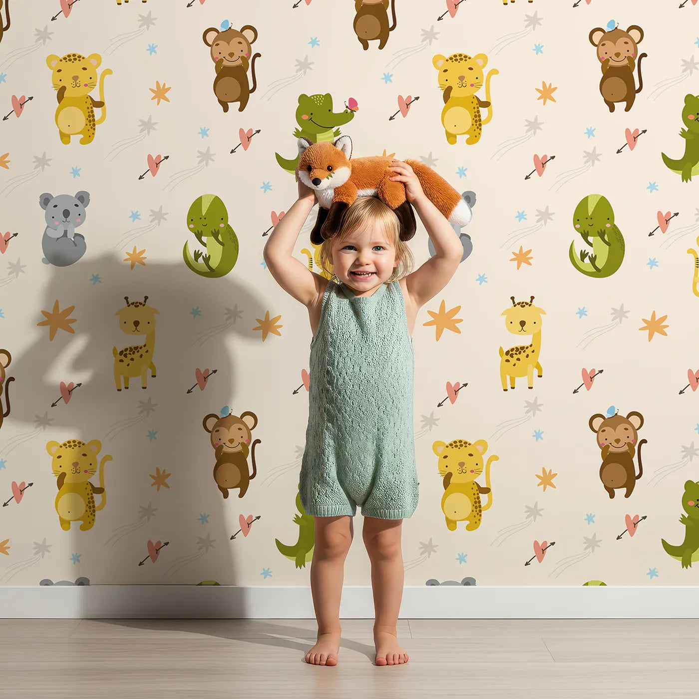 Lovely child standing in front of Whimsy Tots Wild Heart Animal Parade Wallpaper in Cream with giraffe, koala, leopard, monkey, tiger, crocodile, heart, arrow, star in design.