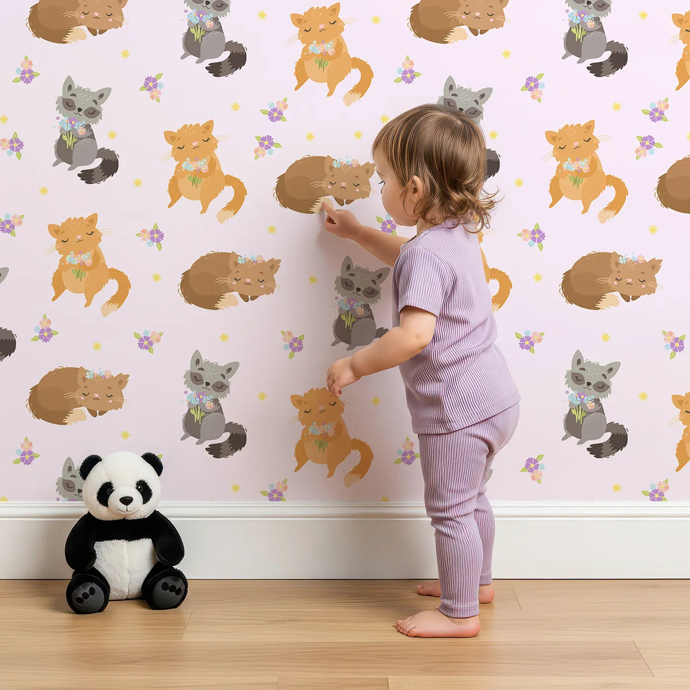 Lovely child standing in front of Whimsy Tots Blossom Fox Nap Parade Wallpaper in Blush Pink with fox, flower, star in design.