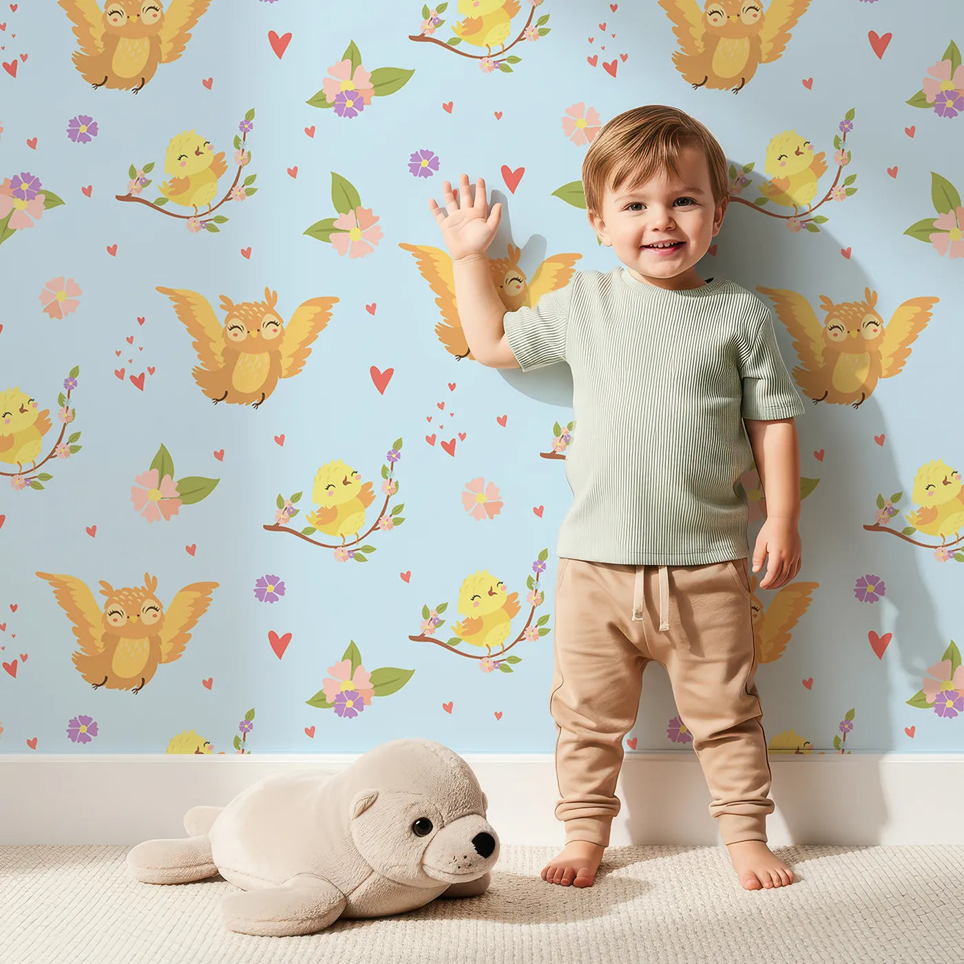 Lovely child standing in front of Whimsy Tots Tweeting Lovebirds Wallpaper in Blue with bird, owl, flower, heart, branch in design.