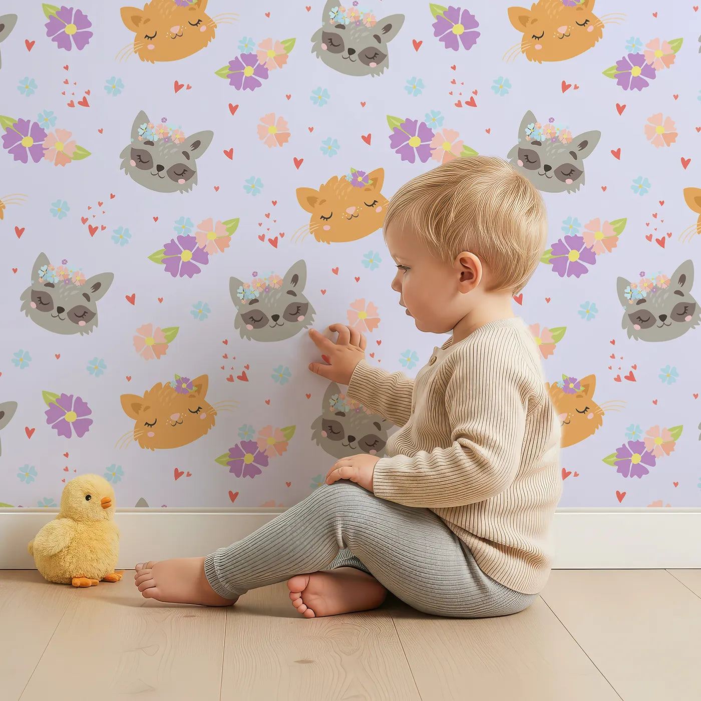 Lovely child standing in front of Whimsy Tots Meadow Snuggle Faces Wallpaper in Lilac Lavender with cat, raccoon, flower, heart in design.