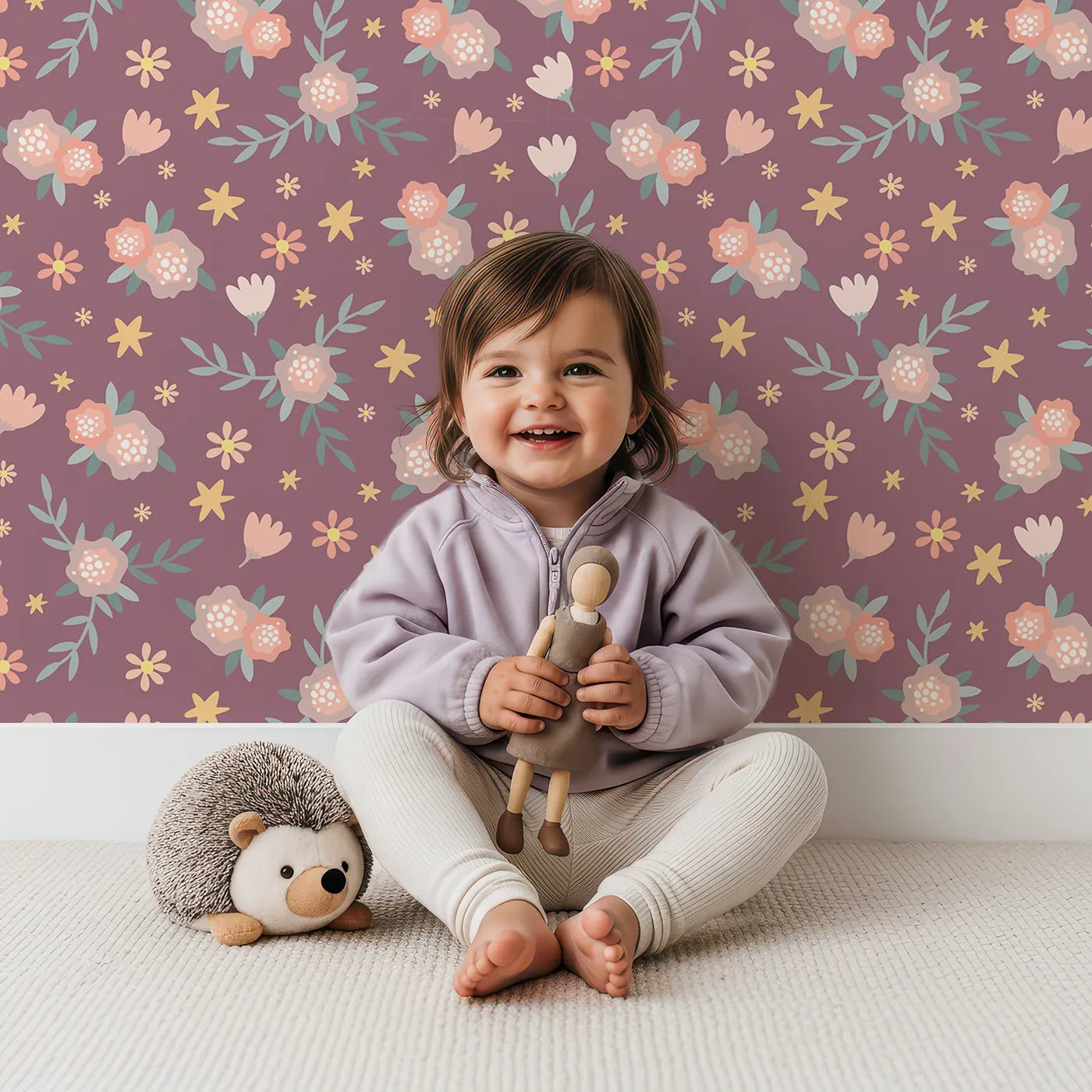Lovely child standing in front of Whimsy Tots Twilight Wildflower Waltz Wallpaper in Plum with flower, star, leaf in design.