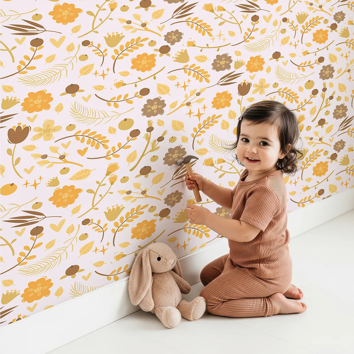 Lovely child standing in front of Whimsy Tots Golden Woodland Whimsy Wallpaper in Blush with leaf, flower, berry, crown in design.