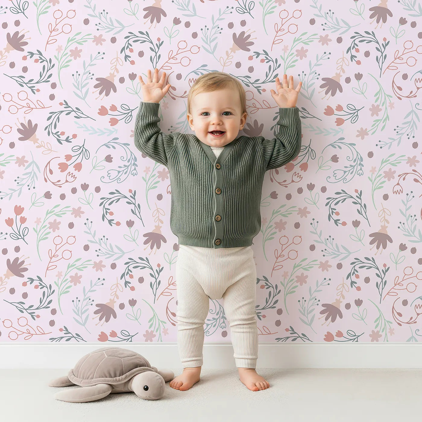 Lovely child standing in front of Whimsy Tots Fairy Petal Garden Wallpaper in Pink with fairy, flower, leaf, berry in design.