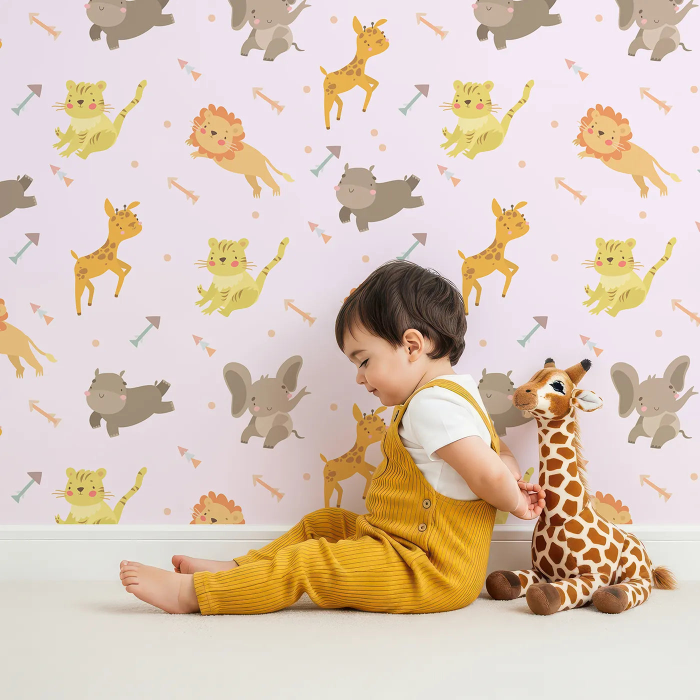 Lovely child standing in front of Whimsy Tots Safari Buddies Parade Wallpaper in Pink with lion, giraffe, elephant, hippo, tiger, arrow in design.