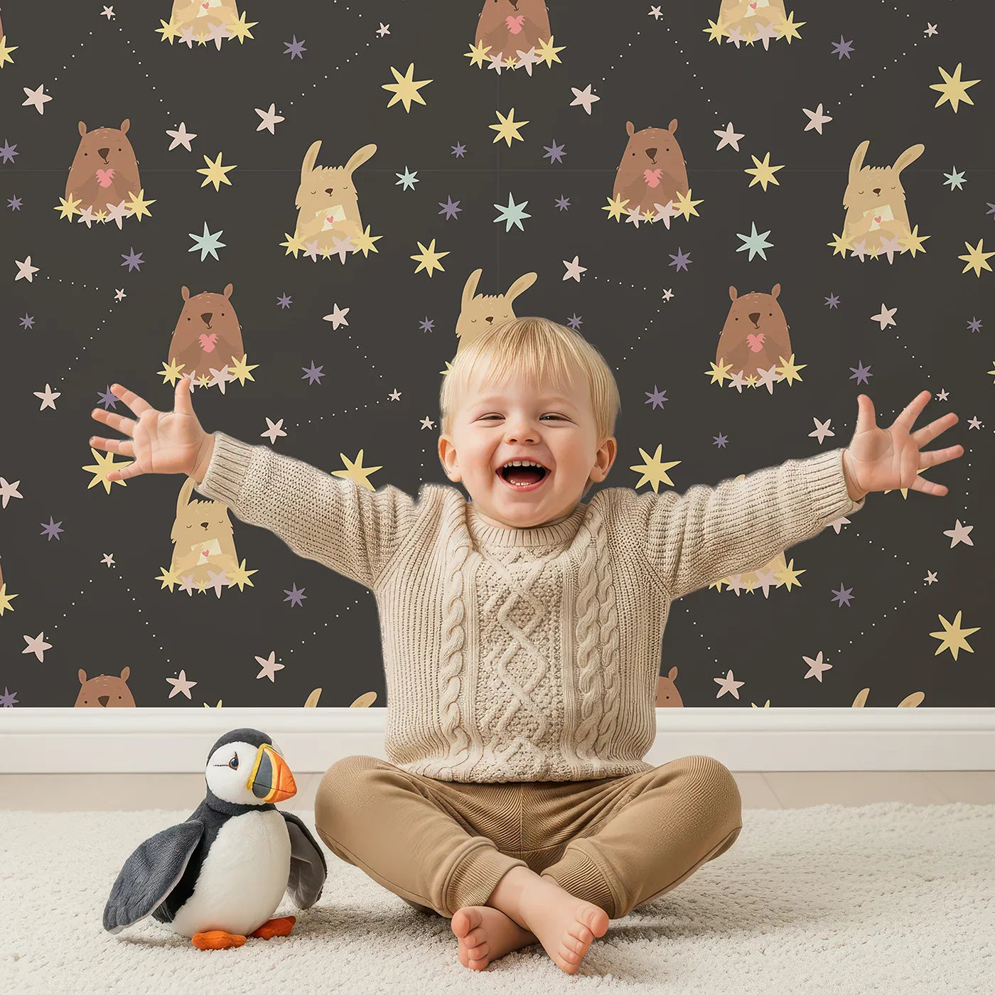 Lovely child standing in front of Whimsy Tots Starry Snuggle Pals Wallpaper in Charcoal Gray with bear, rabbit, star, heart, constellation in design.