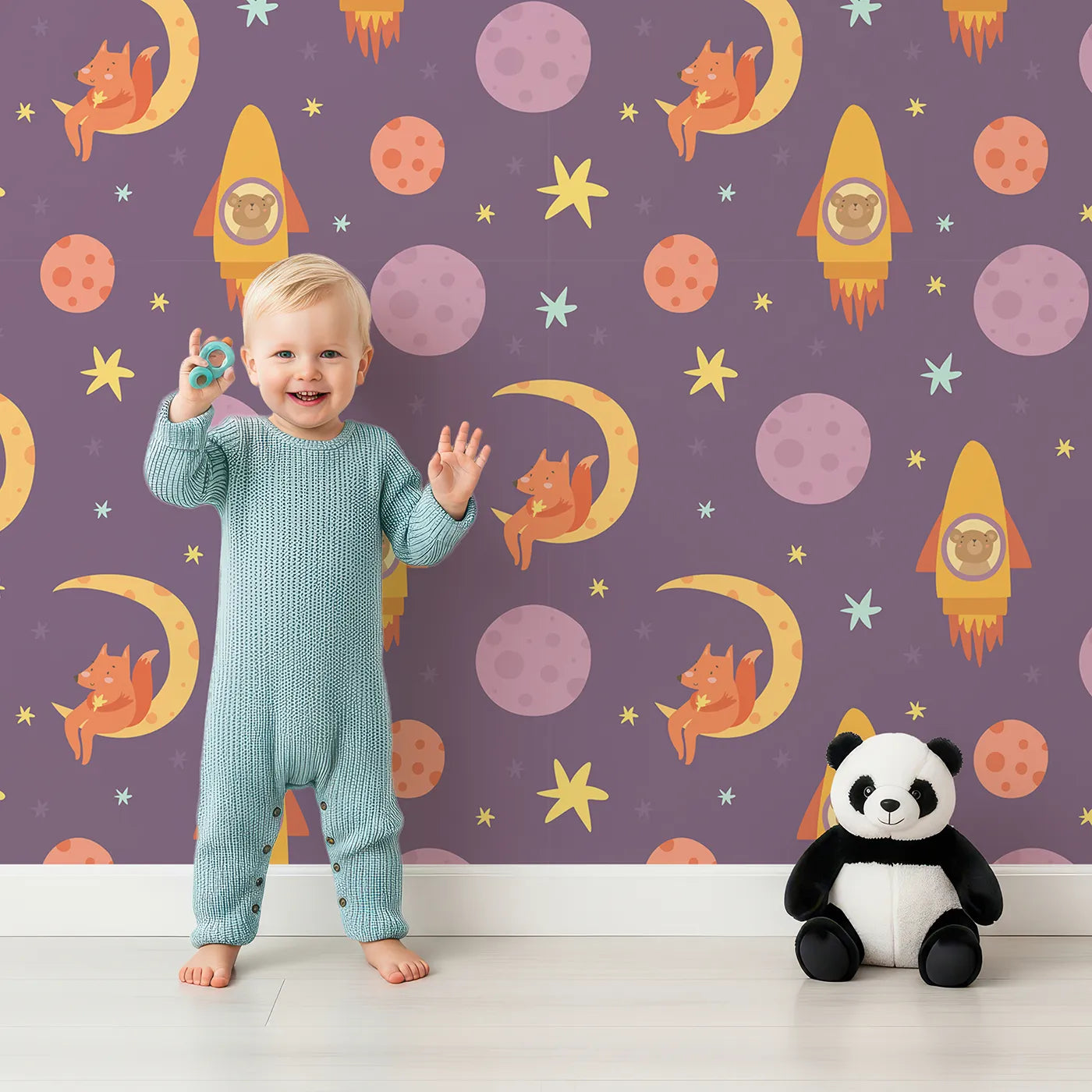 Lovely child standing in front of Whimsy Tots Fox and Koala Space Mission Wallpaper in Plum with fox, koala, moon, rocket, star, planet in design.