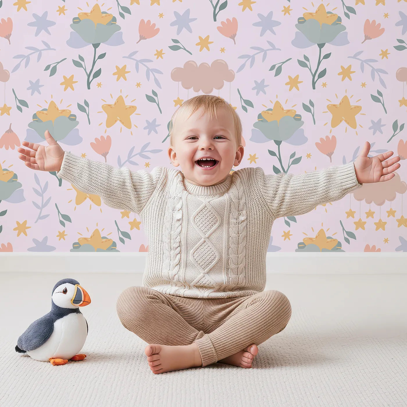 Lovely child standing in front of Whimsy Tots Starlight Blossom Dreams Wallpaper in Petal Pink with star, flower, cloud, leaf in design.
