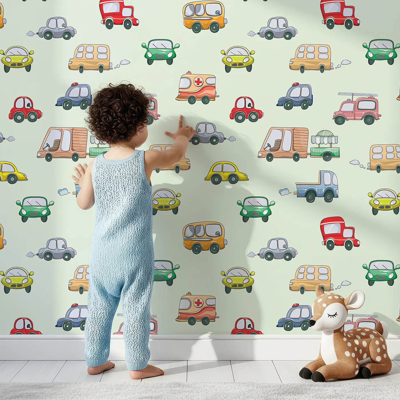 Lovely child standing in front of Whimsy Tots Bumper Buddies Rally Wallpaper in Mint Green with car, truck, bus, foodtruck, taxi in design.