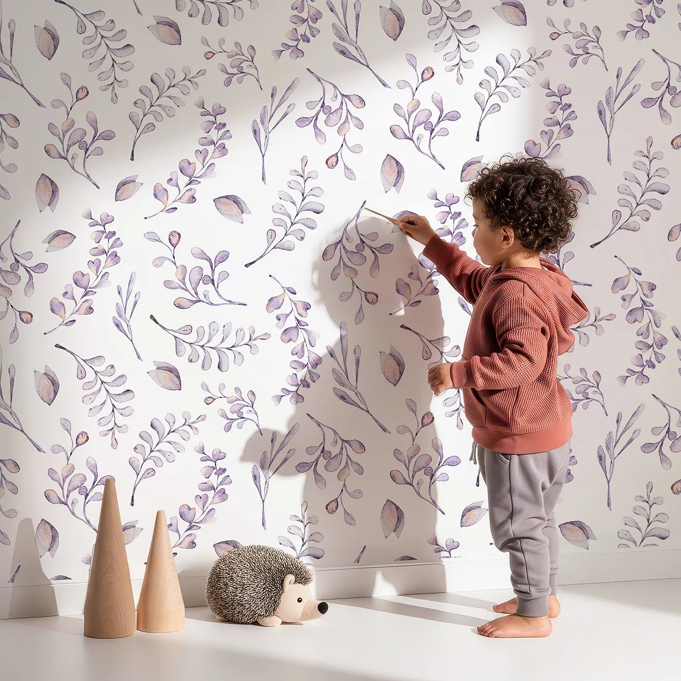 Lovely child standing in front of Whimsy Tots Lavender Breeze Wallpaper with leaf, petal, sprig, lavender in design.