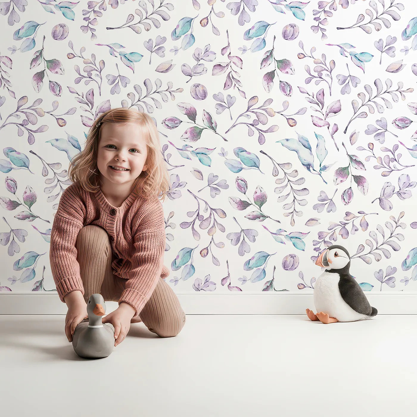 Lovely child standing in front of Whimsy Tots Lavender Breeze Wallpaper II with leaf, sprig, flower, watercolor in design.