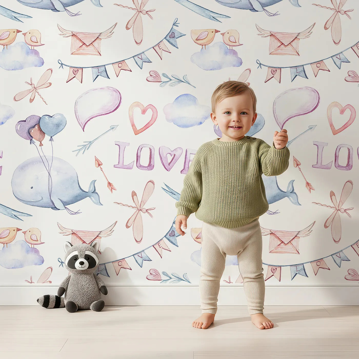 Lovely child standing in front of Whimsy Tots Love in the Sky Wallpaper with whale, balloon, heart, cloud, dragonfly, envelope in design.