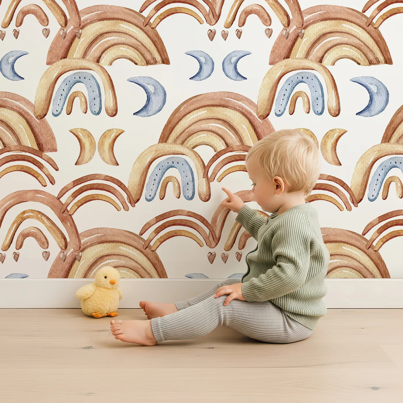 Lovely child standing in front of Whimsy Tots Rainbow Moondance Wallpaper in White with rainbow, moon, arc, heart in design.