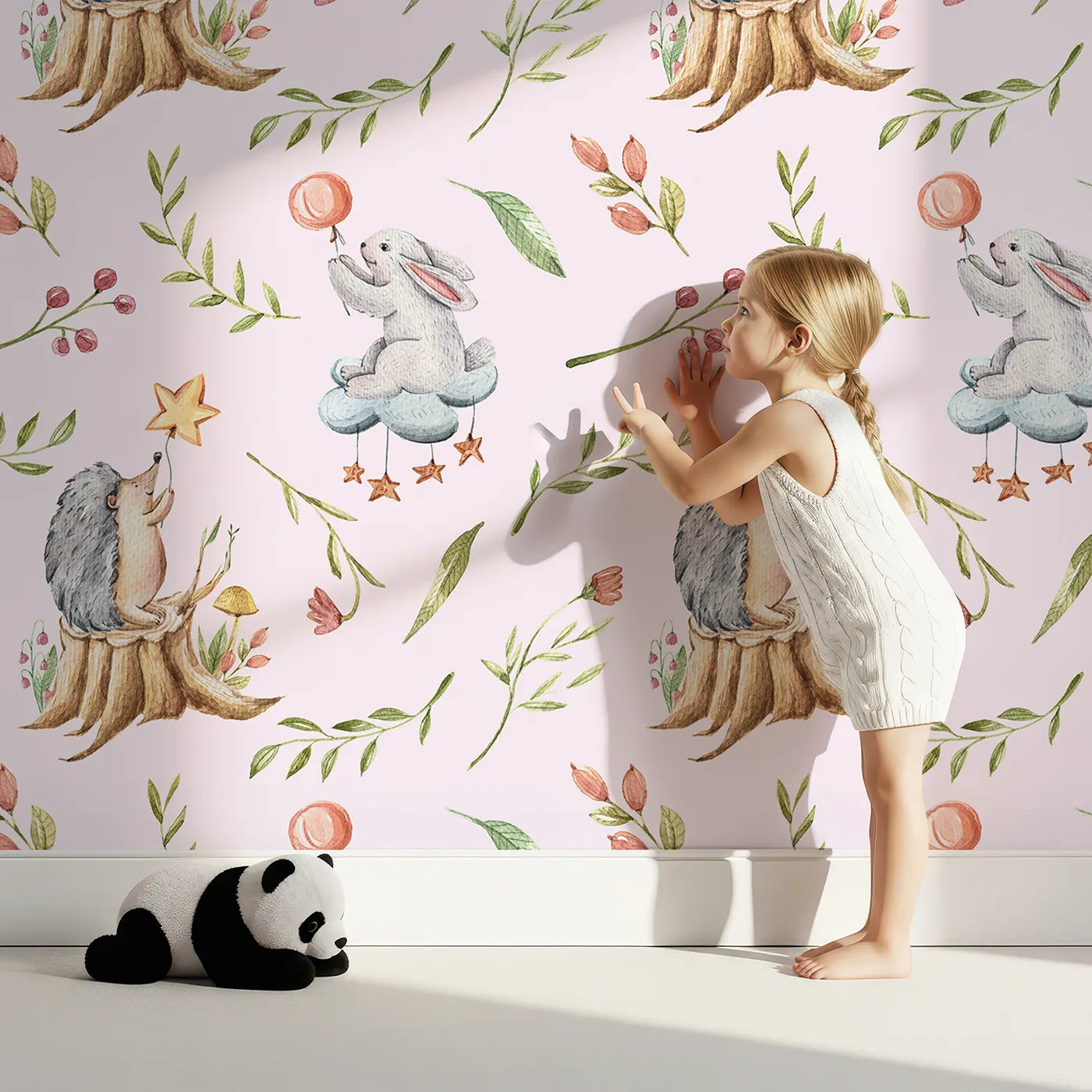 Lovely child standing in front of Whimsy Tots Starlight Forest Friends Wallpaper in Cream with rabbit, hedgehog, star, flower, leaf in design.