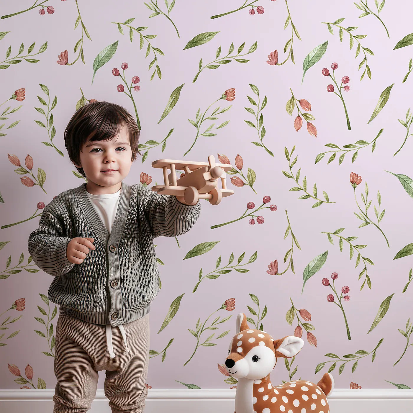 Lovely child standing in front of Whimsy Tots Blossom Meadow Breeze Wallpaper in Blush Pink with flower, leaf, vine, berry in design.