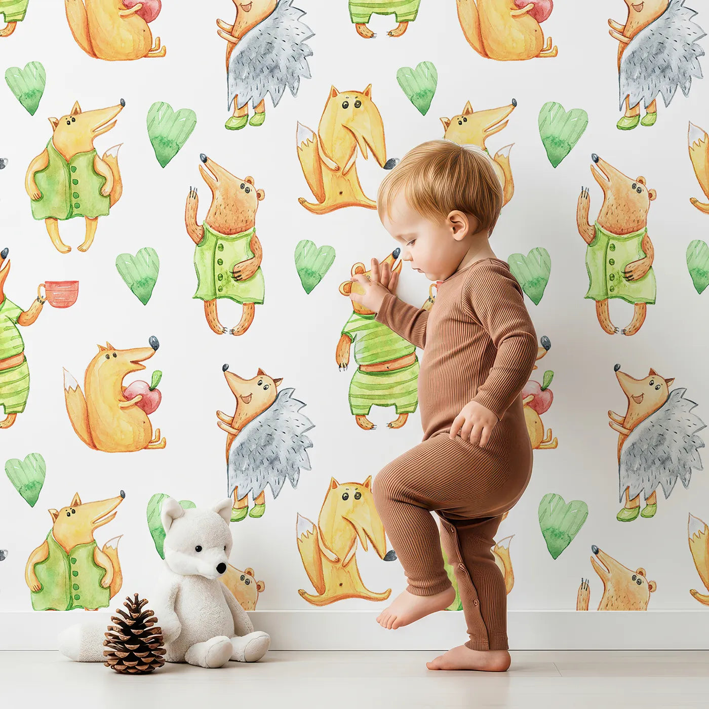 Lovely child standing in front of Whimsy Tots Forest Friends Tea Party Wallpaper in White with fox, hedgehog, bear, heart, cup in design.