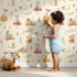 Lovely child standing in front of Whimsy Tots Wishful Woodland Friends Wallpaper in Beige with hedgehog, owl, mouse, snail, mushroom, leaf, pumpkin, star in design. Lovely child standing in front of Whimsy Tots Wishful Woodland Friends Wallpaper in Beige with hedgehog, owl, mouse, snail, mushroom, leaf, pumpkin, star in design.