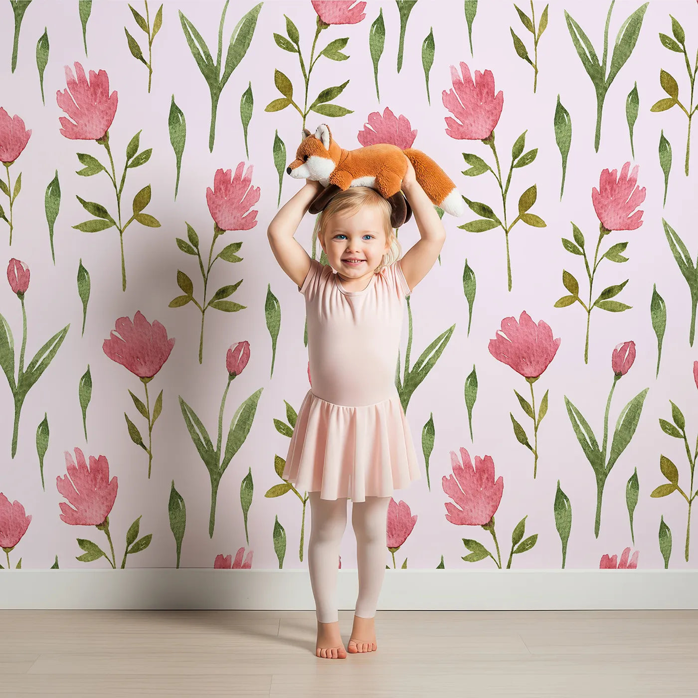 Lovely child standing in front of Whimsy Tots Tulip Meadow Blooms Wallpaper in Blush Pink with tulip, flower, leaf, stem in design.