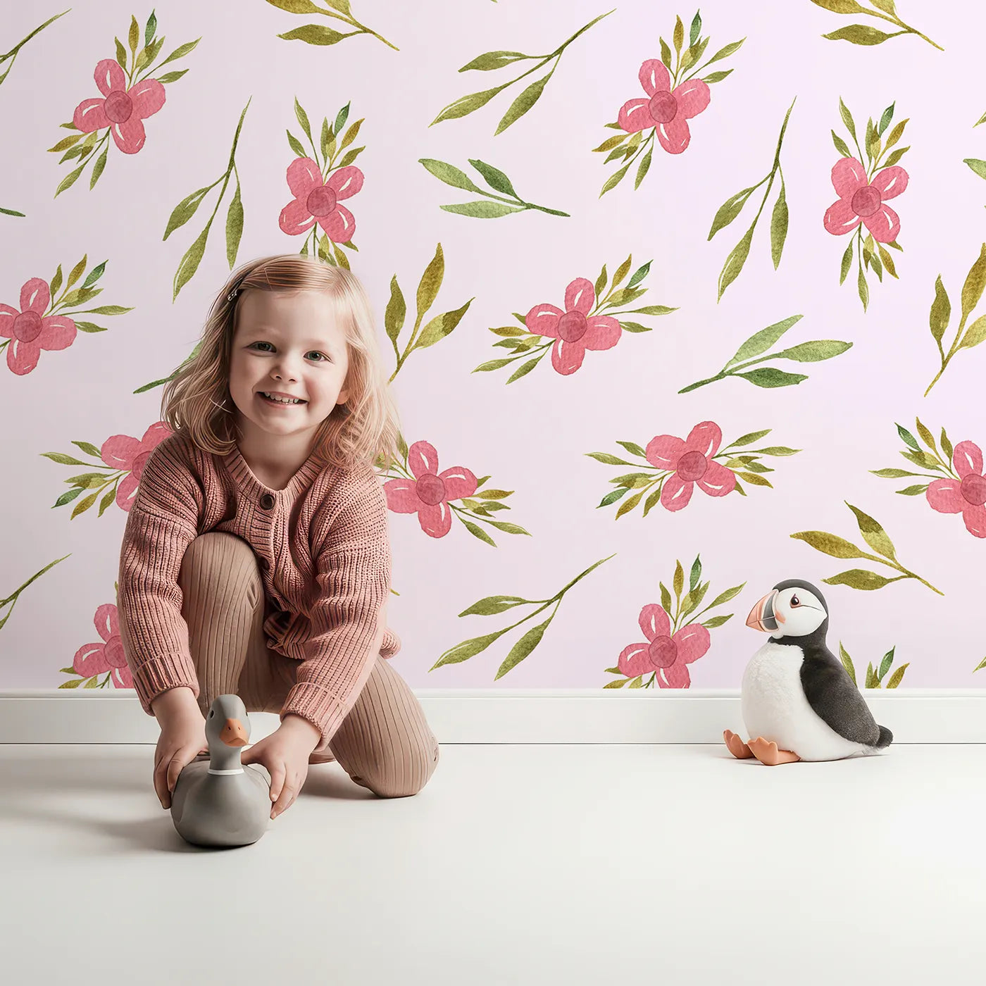 Lovely child standing in front of Whimsy Tots Whimsy Bloom Sprays Wallpaper in Blush Pink with flower, leaf, bloom, spray in design.